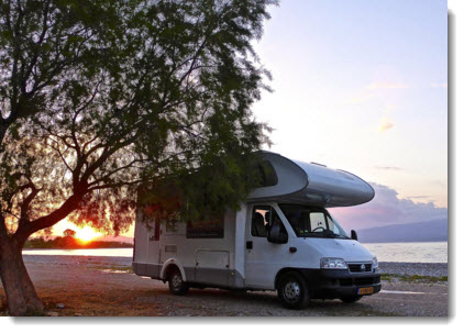 Motorhome parked besides tree - sunset