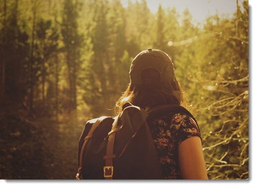 Woman with backpack in forest