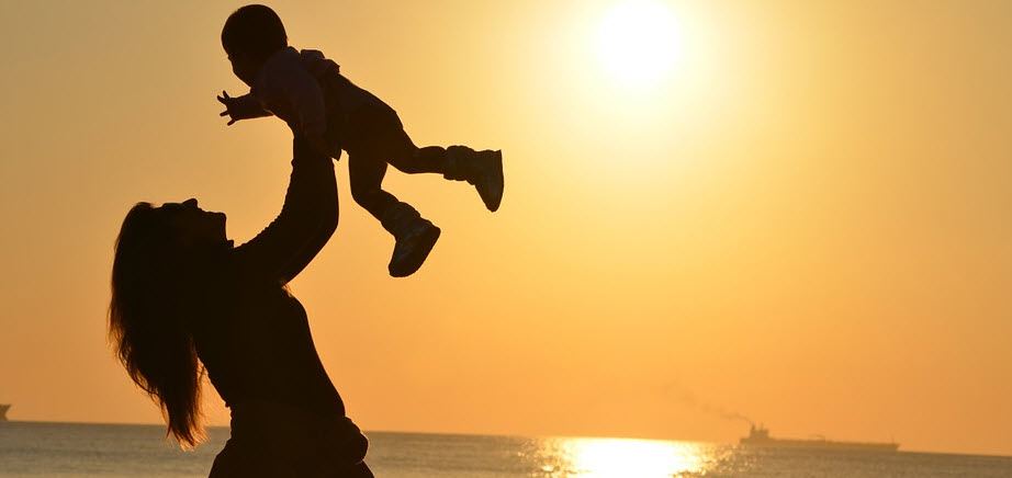 mom with baby in front of the sea